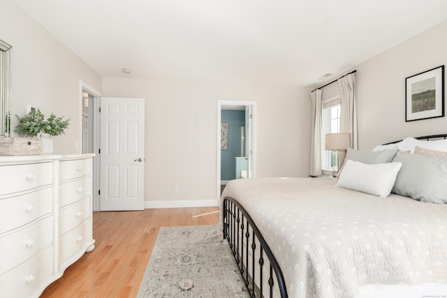 bedroom featuring baseboards and light wood finished floors