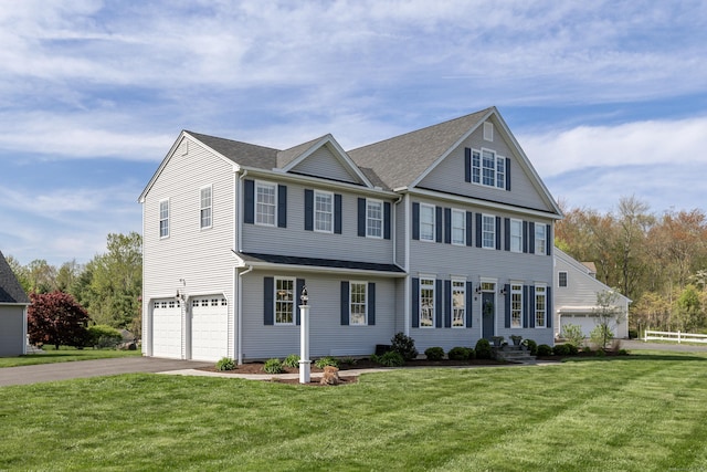 view of front of home with an attached garage, driveway, and a front yard