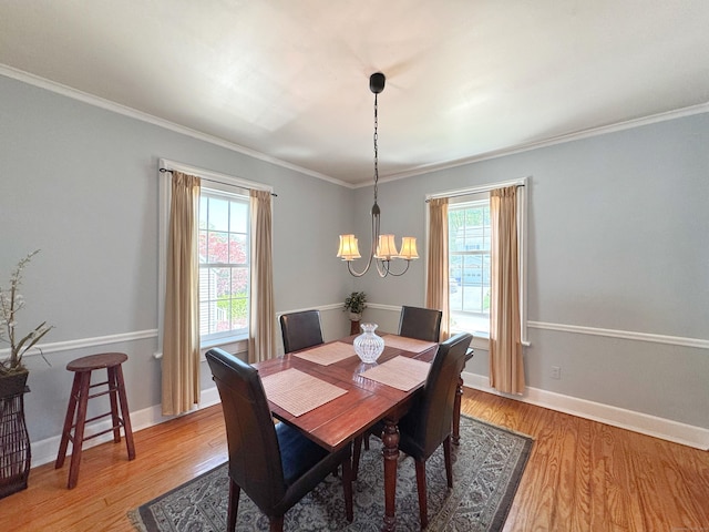 dining room with light wood-style floors, ornamental molding, a chandelier, and a healthy amount of sunlight