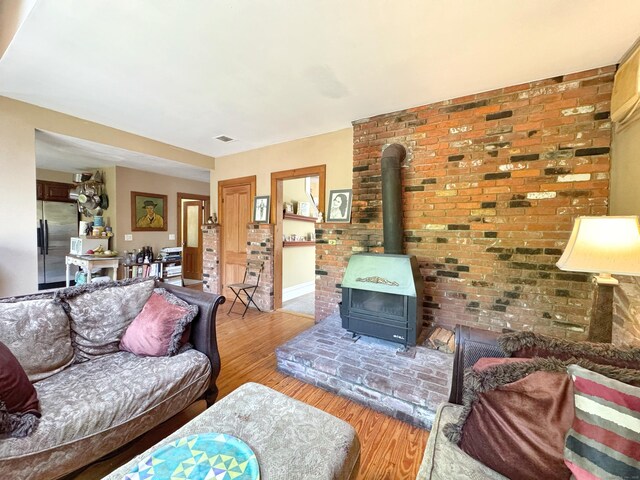 10 Ells St, Norwalk, CT 06850 - living area with wood finished floors, a wood stove, and baseboards