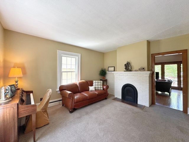 living room featuring carpet floors, a baseboard heating unit, and a fireplace