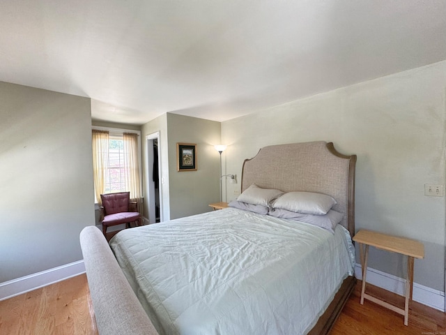 bedroom with baseboards and wood finished floors