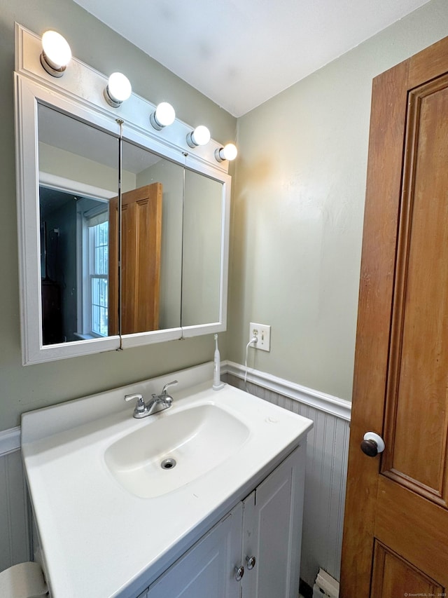bathroom with vanity and a wainscoted wall