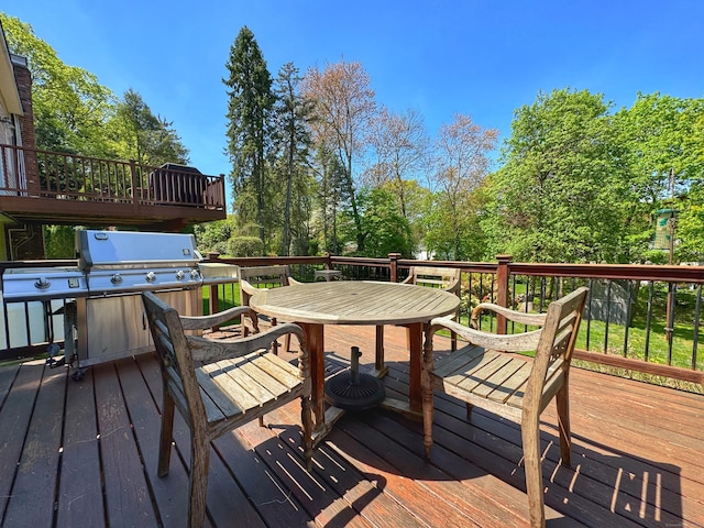 deck featuring outdoor dining area and grilling area