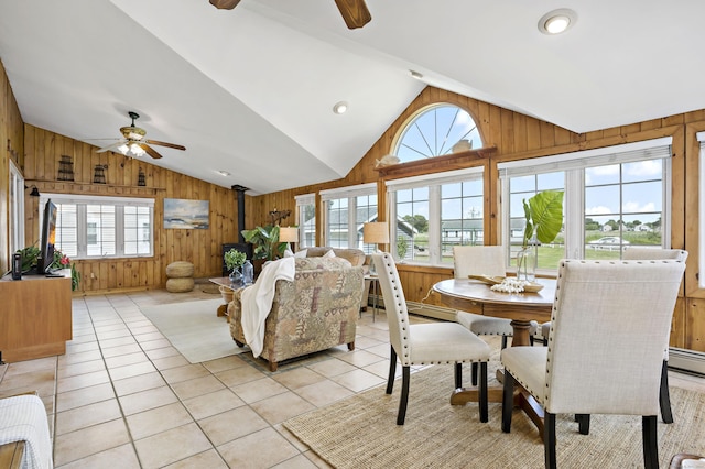 dining area featuring a ceiling fan, wood walls, and vaulted ceiling