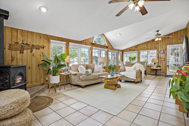86 Chalker Beach Rd, Old Saybrook, CT 06475 - living area with a wood stove, wood walls, light tile patterned flooring, ceiling fan, and vaulted ceiling