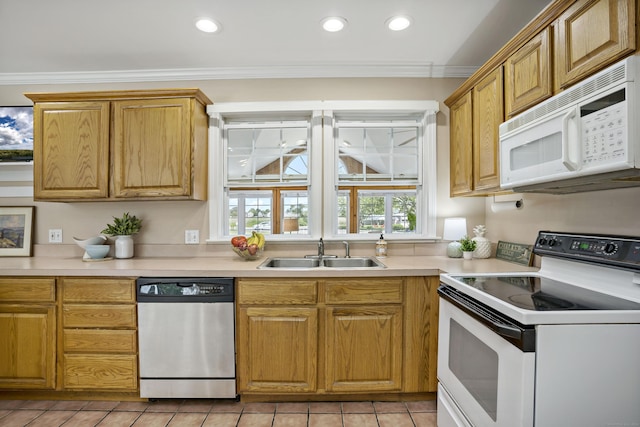 kitchen featuring plenty of natural light, a sink, light tile patterned flooring, and white appliances