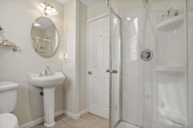 bathroom with baseboards, tile patterned floors, toilet, and a shower stall