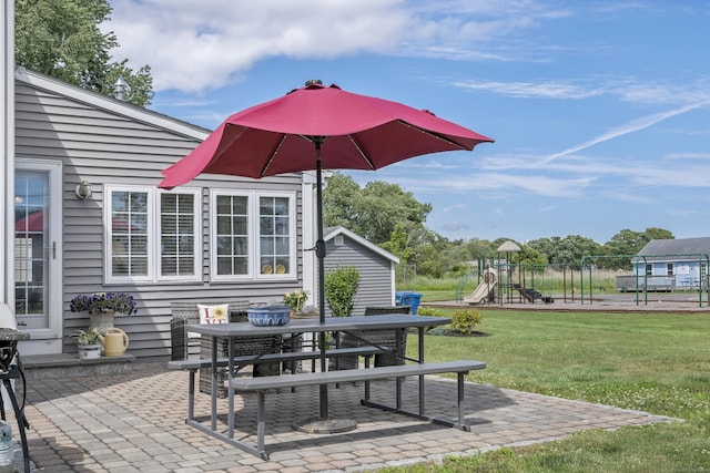 view of patio with a playground and outdoor dining area