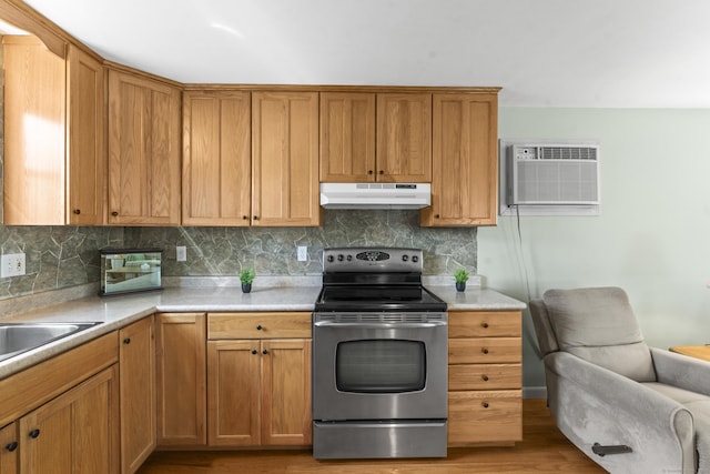 21 Roosevelt Blvd, Enfield, CT 06082 - kitchen featuring stainless steel electric stove, under cabinet range hood, a wall mounted AC, light wood-style flooring, and decorative backsplash