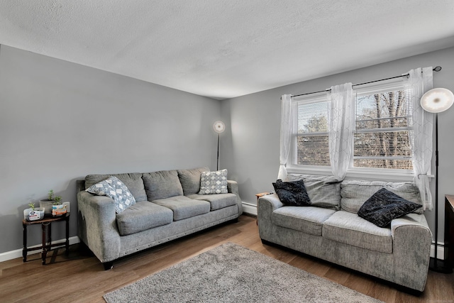living room featuring a baseboard radiator, a textured ceiling, and wood finished floors