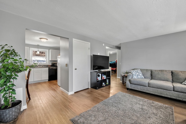 living area with light wood-style floors and a textured ceiling