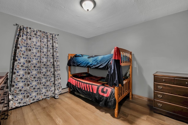 bedroom with a textured ceiling and wood finished floors