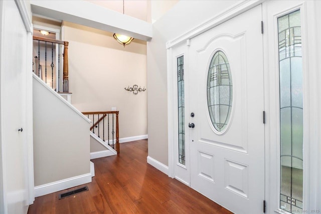 entryway featuring stairs, baseboards, visible vents, and wood finished floors
