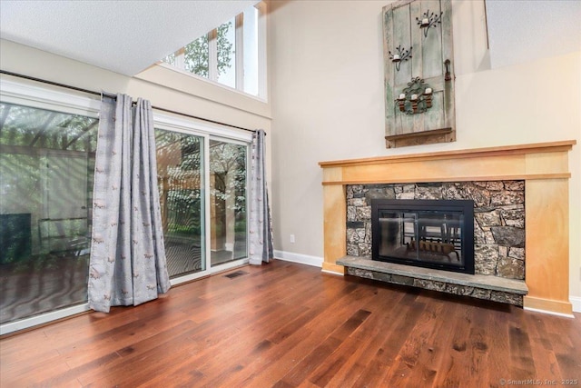 unfurnished living room featuring a wealth of natural light, visible vents, and wood finished floors