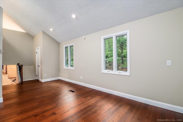 spare room with a wealth of natural light, baseboards, hardwood / wood-style floors, and a textured ceiling