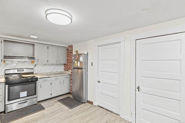 kitchen with backsplash, open shelves, light countertops, light wood-style floors, and stainless steel appliances
