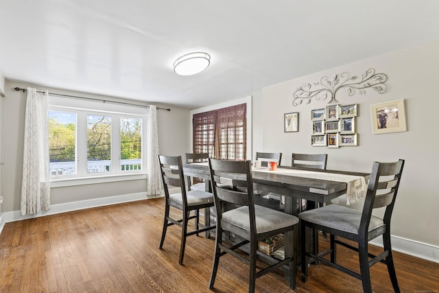 dining area with baseboards and wood finished floors