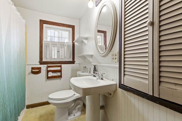 bathroom with wainscoting and toilet