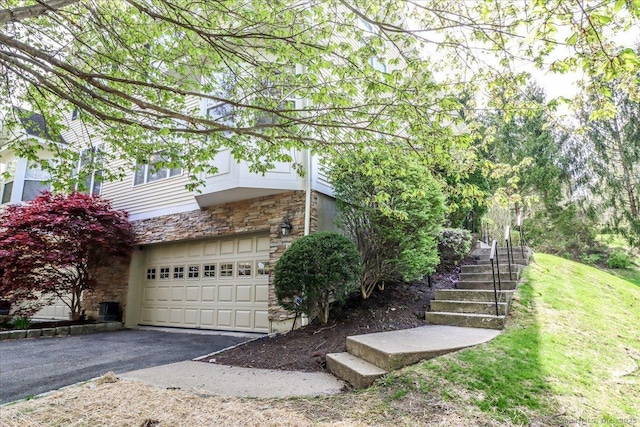 21 Woodcrest Ln Unit 21, Danbury, CT 06810 - view of home's exterior featuring driveway, stairs, stone siding, and a garage