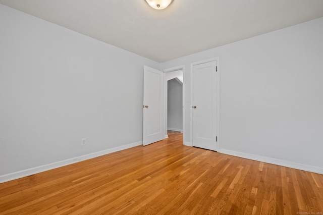 unfurnished room featuring baseboards and light wood finished floors
