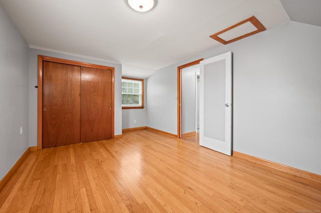 unfurnished bedroom with light wood-type flooring, baseboards, and a closet