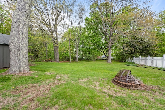 view of yard featuring fence and a fire pit