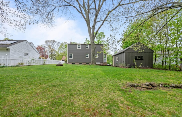 view of yard with fence and an outbuilding