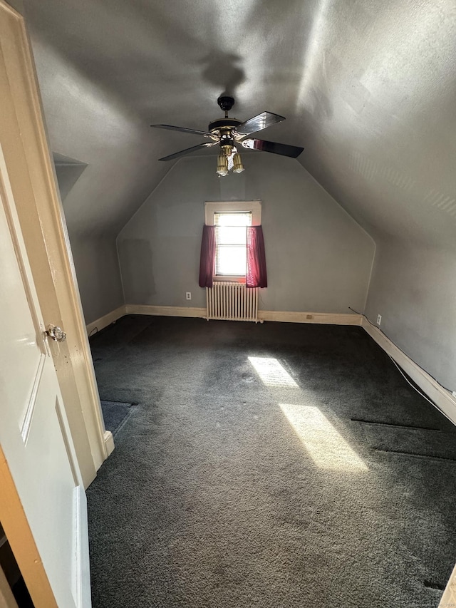 additional living space featuring ceiling fan, carpet floors, radiator, baseboards, and lofted ceiling