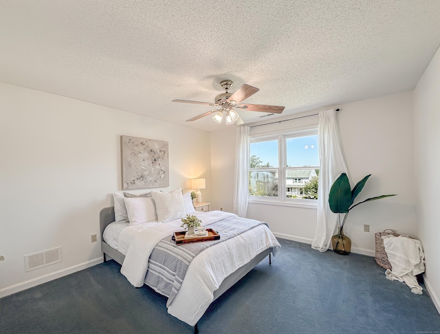 carpeted bedroom with baseboards, ceiling fan, a textured ceiling, and visible vents
