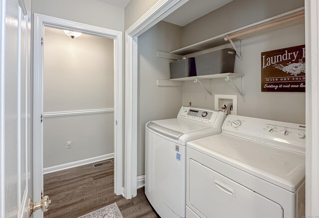 washroom featuring laundry area, dark wood finished floors, washing machine and dryer, and visible vents