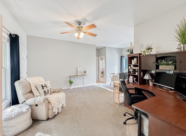 home office with baseboards, a ceiling fan, carpet, and a textured ceiling
