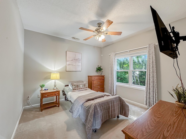 bedroom with visible vents, baseboards, a textured ceiling, a ceiling fan, and carpet