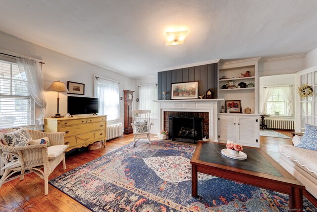 2951 Winsted Rd, Torrington, CT 06790 - living room with radiator heating unit, wood finished floors, and a fireplace