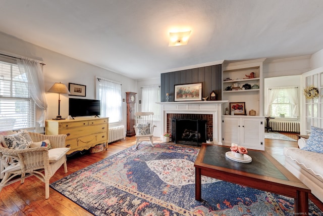 2951 Winsted Rd, Torrington, CT 06790 - living area with radiator, wood finished floors, and a brick fireplace