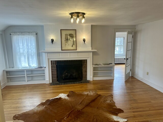 2951 Winsted Rd, Torrington, CT 06790 - living area with radiator heating unit, wood finished floors, a fireplace, and baseboards
