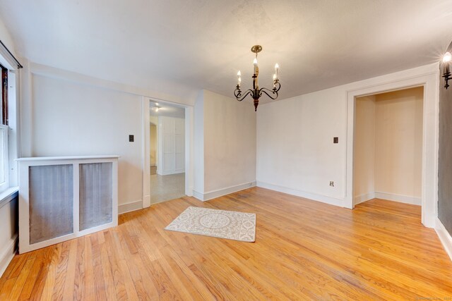 2951 Winsted Rd, Torrington, CT 06790 - empty room featuring a chandelier, light wood-style floors, and baseboards