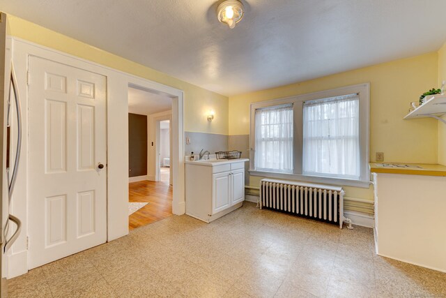 2951 Winsted Rd, Torrington, CT 06790 - kitchen featuring radiator heating unit, light countertops, refrigerator, light floors, and white cabinets