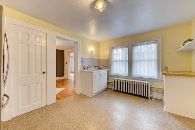2951 Winsted Rd, Torrington, CT 06790 - kitchen featuring radiator heating unit, light countertops, refrigerator, light flooring, and white cabinets