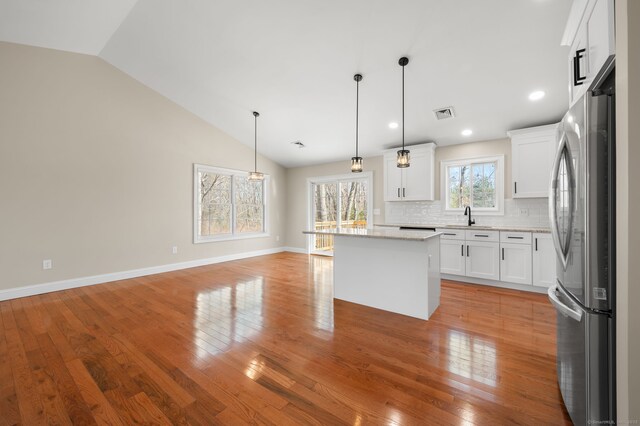 74 N Wawecus Hill Rd, Norwich, CT 06360 - kitchen with freestanding refrigerator, a sink, vaulted ceiling, light wood-style flooring, and white cabinets