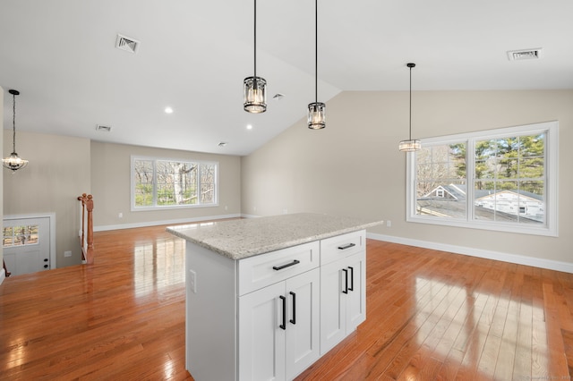 74 N Wawecus Hill Rd, Norwich, CT 06360 - kitchen with light wood-style flooring, lofted ceiling, hanging light fixtures, a center island, and light stone counters