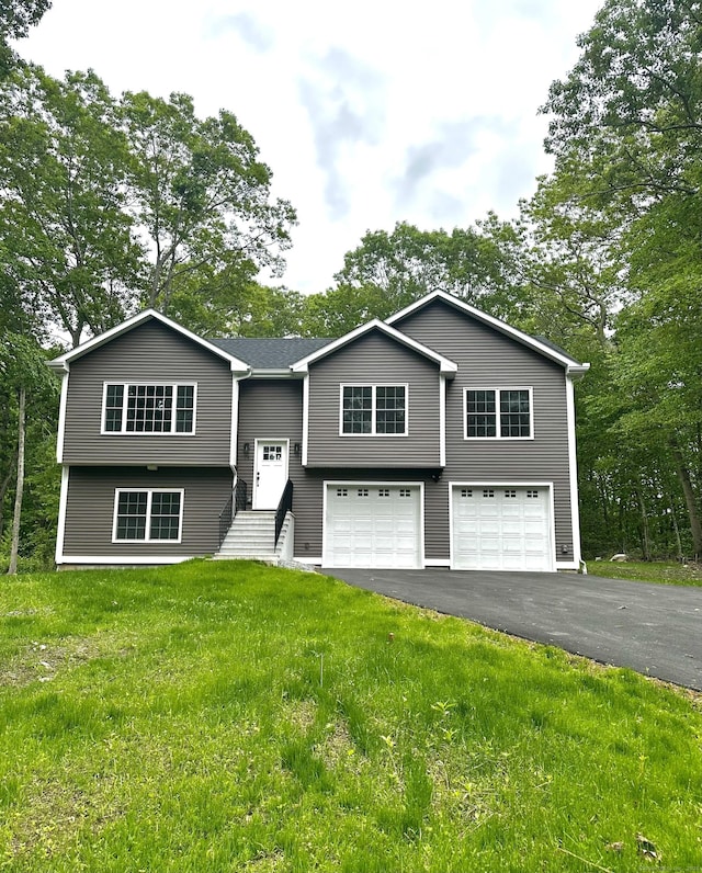 74 N Wawecus Hill Rd, Norwich, CT 06360 - bi-level home with a garage, asphalt driveway, and a front lawn