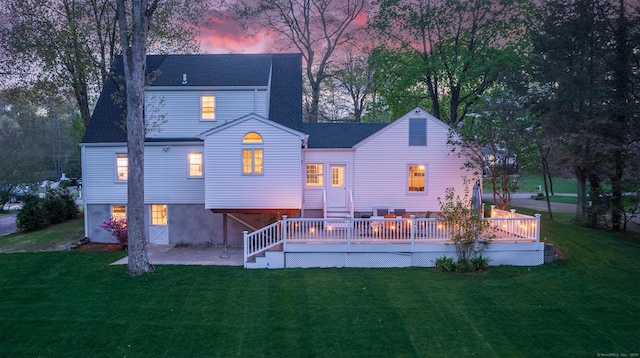 rear view of house with a yard, a shingled roof, a deck, and a patio