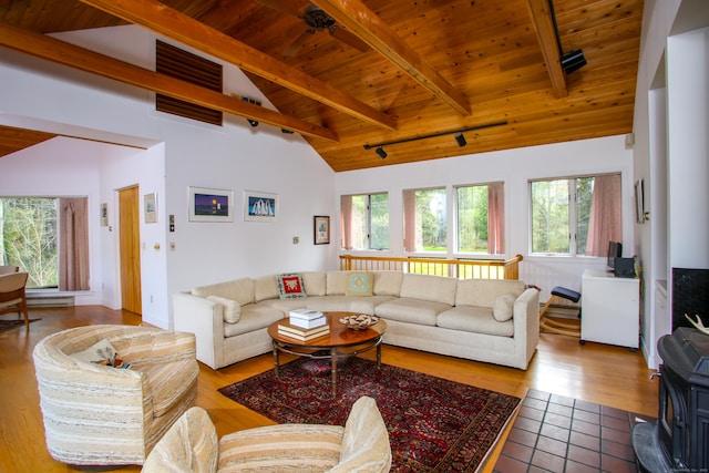tiled living room with wooden ceiling, a wood stove, and vaulted ceiling with beams