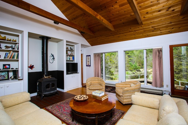 living area with wooden ceiling, a wood stove, plenty of natural light, and vaulted ceiling with beams