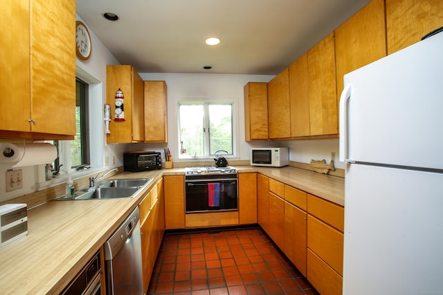 kitchen with recessed lighting, a toaster, white appliances, a sink, and light countertops