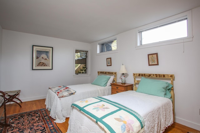 bedroom with baseboards and wood finished floors