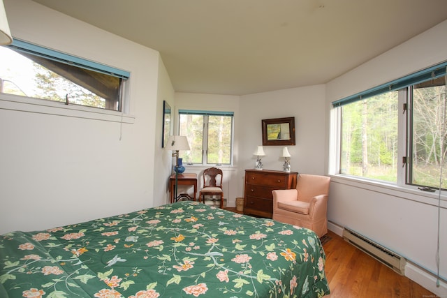 bedroom featuring baseboard heating and wood finished floors