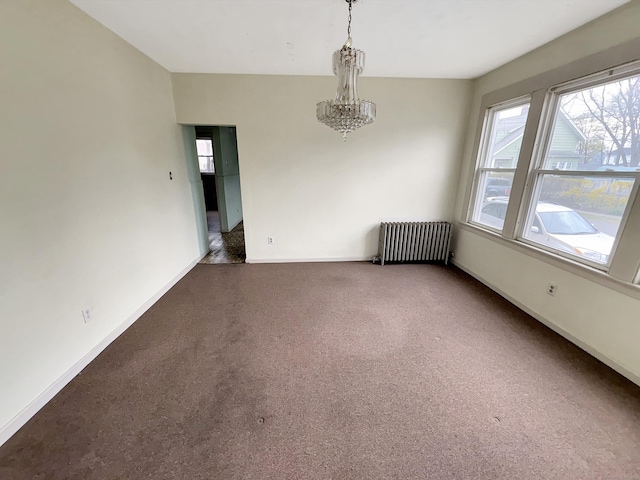carpeted spare room with baseboards, a chandelier, radiator heating unit, and a wealth of natural light