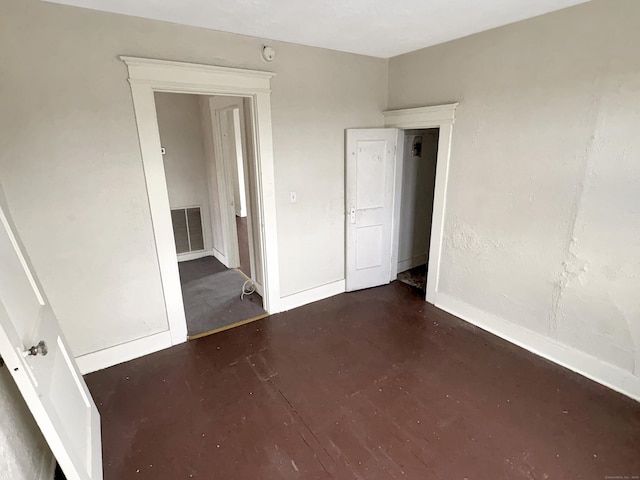 unfurnished bedroom with baseboards, finished concrete flooring, and visible vents